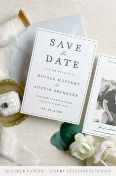 the wedding stationery is laid out next to an envelope, ring and boutonniere