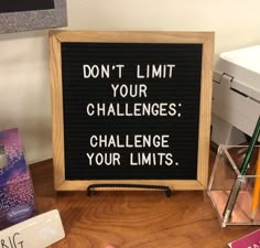 a sign that says don't limit your challenges challenge your limits on the desk