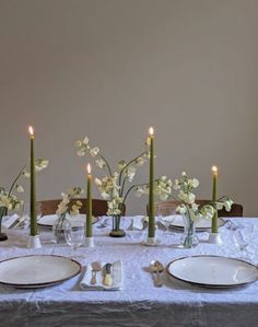 the table is set with plates and candles