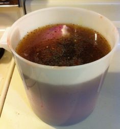 a cup filled with liquid sitting on top of a stove