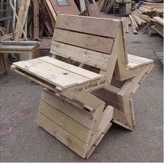 a bench made out of wooden pallets sitting on the ground next to other pieces of wood