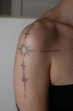 a woman's arm with a tattoo on it that has an arrow and sun