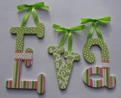 two wooden letters decorated with green ribbons and bows, one says love on the other