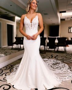 a woman in a white wedding dress posing for the camera with her hands on her hips