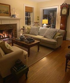 a living room filled with furniture and a fire place under a clock mounted on the wall