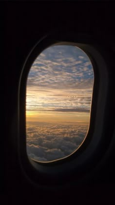 an airplane window looking out at the clouds