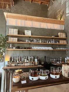 the coffee bar is stocked with many different types of cups and mugs on shelves