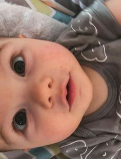 a close up of a baby laying on top of a bed