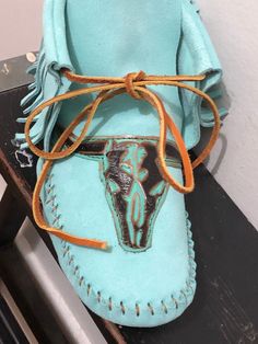 These handmade moccasins will not disappoint.  Crafted of a vibrant aqua suede and adorned with the longhorn. Completely made of leather. Western Style Slip-on Moccasins For Festivals, Western Leather Moccasins For Festival, Western Style Leather Moccasins For Festivals, Artisan Handmade Leather Moccasins, Leather Moccasins Diy, Native American Boots, Moccasin Patterns, Diy Moccasins, Native American Moccasins