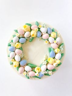 a decorated cake with flowers and eggs on it