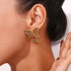 These Large Gold Butterfly Earrings make a bold statement with their stunning design. Perfect for adding a touch of elegance and sophistication to any outfit. These earrings will surely catch attention and elevate any look. DETAILS & SIZE Sold as a pair Finish: 18K gold plate Material: Stainless Steel Measurements: 1.6"x1.2" Weight: 12.6 grams Comes with friction earring backs Waterproof, tarnish-resistant, and nickel free Shop Earrings to curate your ear stack! Gold Plated Single Bridal Earring, Modern Bridal Earrings For Parties, Yellow Gold Plated Bridal Earrings, Luxury Gold Butterfly Earrings, Elegant Butterfly Earrings For Formal Occasions, Elegant Gold Butterfly Earrings, Elegant Gold Butterfly-shaped Earrings, Gold Butterfly Earrings For Formal Occasions, Dangle Clip-on Earrings With Plating