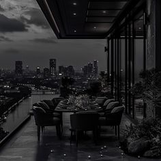 an outdoor dining area overlooking the city at night with lights on and dark clouds in the sky