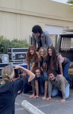 a group of people are posing in front of a truck with their arms around each other