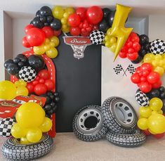 a birthday party with balloons, tires and race car decorations in a box on top of a table