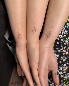 two people with matching tattoos on their arms and fingers, both holding each other's hands