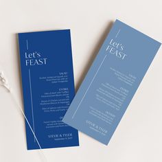 two blue and white wedding programs on a table