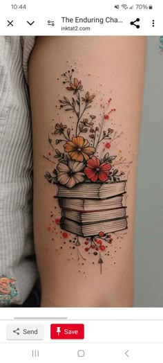 a tattoo with flowers and books on it