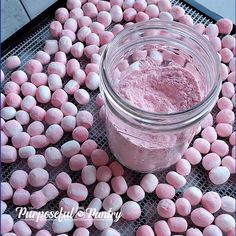 a jar filled with pink marshmallows sitting on top of a metal grate