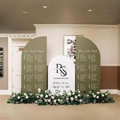 a wedding ceremony setup with flowers and greenery in front of the seating chart for an event