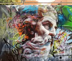 a wall covered in graffiti with a man's face painted on it