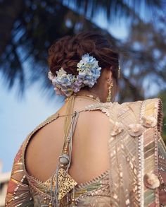 a woman with flowers in her hair is wearing a dress and looking off into the distance