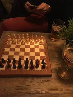 a man sitting at a table with a chess board and cell phone in front of him