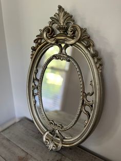 an ornate silver mirror on the wall