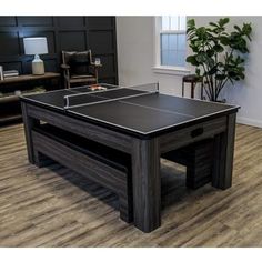 a ping pong table in the middle of a room with wood floors and furniture