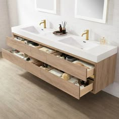 a bathroom with two sinks and mirrors on the wall next to a wooden flooring