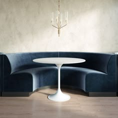 a white table sitting on top of a blue couch next to a chandelier