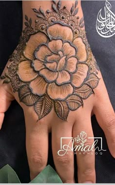 a woman's hand is decorated with hennap and flower designs on it