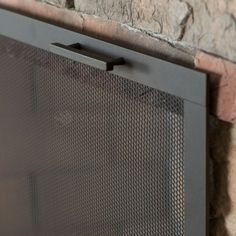 a close up view of a brick wall with a metal screen on the front and side