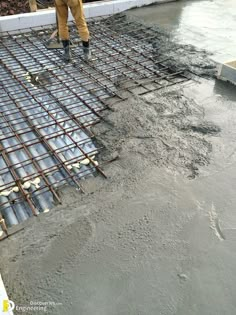 a man standing on top of a metal grate in the middle of a cement floor