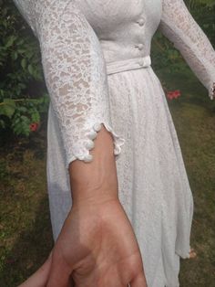 "Vintage 70s wedding gown. Long sleeve lace wedding dress. Stand up collar, front buttoned up, two layers. Seems like home made or tailored. S/M size. From shoulder to shoulder 16\" 41cm Bust 34\" 86cm Waist 28\" 71cm Sleeve length 20\" 51cm Length in front 59\" back 61\"" Elegant Wedding Lace Dress With Lace Cuffs, Elegant Lace Wedding Dress With Lace Cuffs, Long Sleeve Lace Trim Wedding Dress, Lace Wedding Dress With Lace Cuffs, Long Sleeve Scalloped Lace Wedding Dress, Fitted Wedding Dress With Buttons, Feminine Lace Dress With Lace Collar For Wedding, Elegant Long Sleeve Wedding Dress With Lace Trim, Long Sleeve Lace Wedding Dress With Lace Cuffs