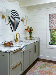 a kitchen with marble counter tops and gold faucets on the wall above it