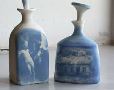 two blue and white vases sitting next to each other