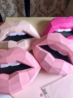 two pink paper bags with the faces of women's lips cut out to look like they have their mouths open