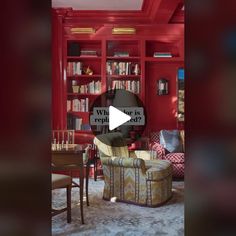 a living room filled with lots of furniture and bookshelves covered in red walls