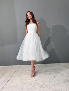 a woman in a white dress posing for the camera