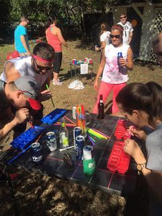 a group of people standing around a table with drinks on it