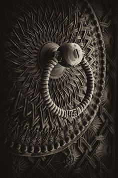 a black and white photo of an intricately designed wall decoration with two balls in the middle