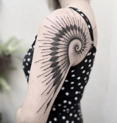 a woman with a black and white tattoo on her arm