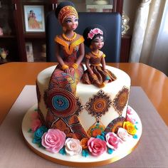 an elaborately decorated cake sits on a table with two dolls sitting on top of it