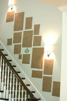 a staircase with several pieces of paper taped to the wall and some lights on either side