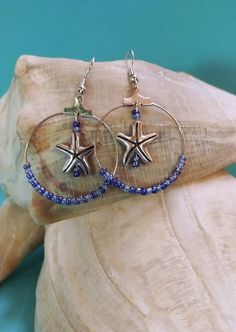 Ocean Tides and Waves Sapphire Blue Beaded Starfish Earrings. Blue glass seed beads strung on a silver colored hood. Starfish charm position in the center of hoop. These are a must for beach trip or any summer vacation event. Makes a great gift. Starfish-shaped Beaded Beach Jewelry, Blue Starfish Charm Jewelry For The Beach, Starfish-shaped Beaded Jewelry For The Beach, Blue Starfish Charm Jewelry For Summer, Summer Beaded Starfish Jewelry, Blue Starfish Jewelry For Beach, Blue Summer Jewelry With Starfish Charm, Summer Blue Starfish Charm Jewelry, Blue Starfish Beach Jewelry