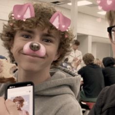 two young boys with fake nose and nose rings holding cell phones in front of them