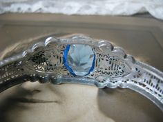 A beautiful Art Deco blue and clear paste floral filigree bangle bracelet. It measures 3/4'' at widest Measures 2 3/8'' x 2'' across the inside, and is 6 3/4'' along the inside. in very good condition with some graying and yellowing to the clear paste stones Blue Wedding Jewelry With Intricate Design, Antique Blue Jewelry For Wedding, Adjustable Filigree Bracelets For Wedding, Antique Blue Bracelet As Gift, Wedding Filigree Bangle Bracelets, Blue Bangle Bracelets For Wedding, Wedding Filigree Bangle, Wedding Filigree Adjustable Bracelets, Blue Bangle Bracelet For Wedding