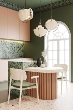 a modern kitchen with green walls and white counter tops, along with an oval dining table surrounded by chairs