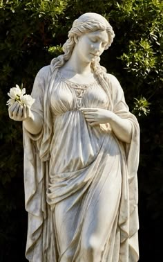 a statue of a woman holding a flower