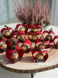 there are many heart shaped candies on the table with flowers in the vase behind them